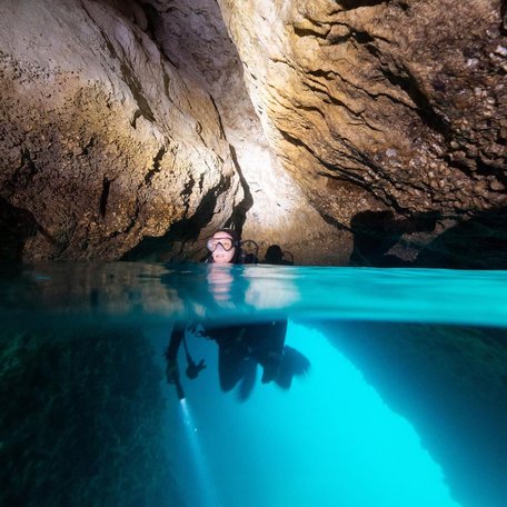 Diver swimming through a cave that is part of The Passage 