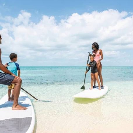 Family paddle boarding on the beach at Old Bahama Bay 