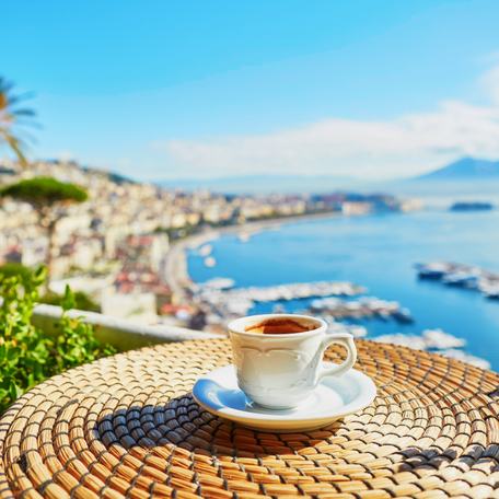 A cup of coffee on a small table overlooking the Amalfi Coast