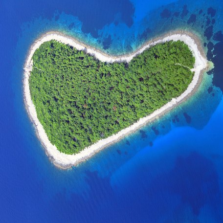 An aerial view looking down on an island in the shape of a heart