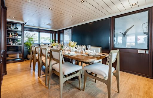 Interior dining area with long table onboard luxury yacht charter GALILEO