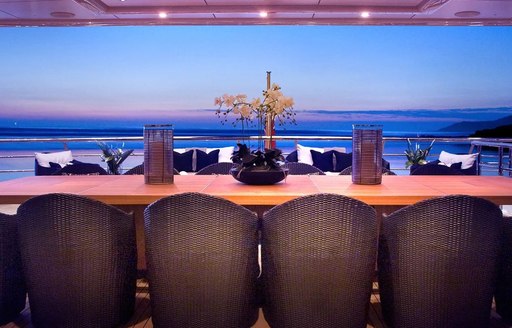 View across deck dining table to sea on superyacht Sea Rhapsody