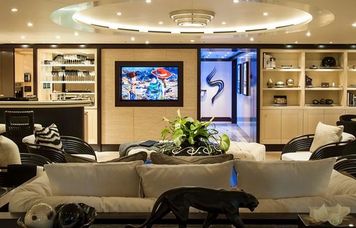 Lounge area on superyacht Sea Rhapsody with artwork on wall and sculptures visible