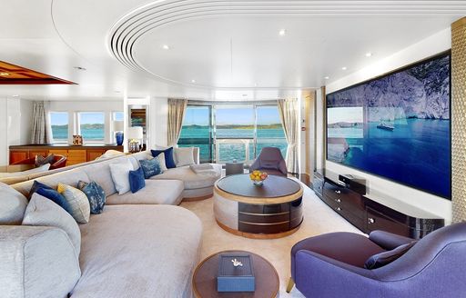 Interior lounge area onboard superyacht charter AFTER YOU with large wall-mounted TV