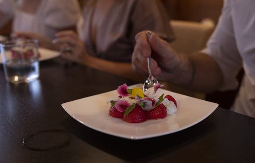 Guest enjoying dessert at the formal dining table on board charter yacht XUMI