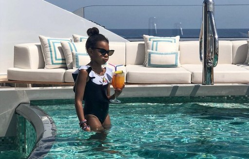 Blue Ivy in pool with mocktail aboard superyahct KISMET