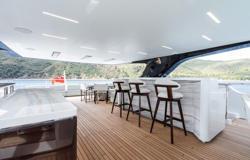 Exteriors onboard charter yacht M with a wet bar and white stools