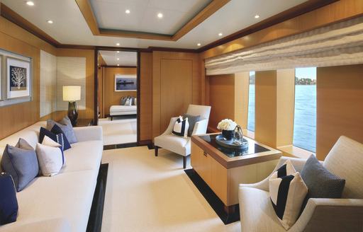 Overview of master cabin study with bureau and white sofa onboard charter yacht LA BLANCA