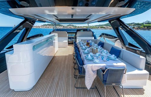 Upper deck layout with long table onboard charter yacht ARSANA