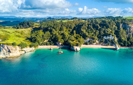 Aerial view on a remote ocean coast with small coves and mountains on the background. Coromandel, New Zealand.