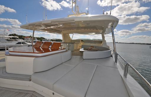 Overview of the sun deck onboard boat charter VIVERE, with sunpads in the foreground plus seating aft