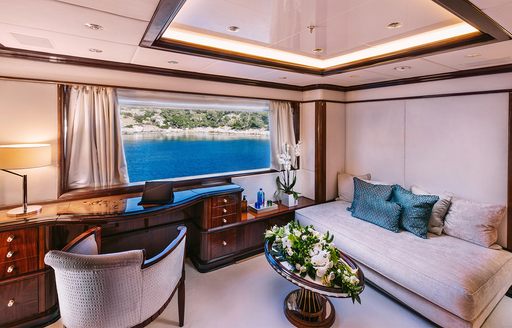 Private seating area and large window in master cabin onboard charter yacht IDYLLIC