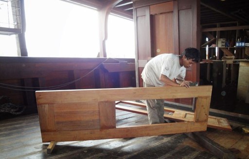 A master carpenter constructs a door for luxury phinisi Dunia Baru