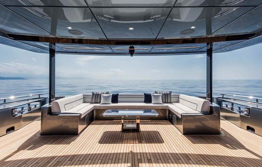 Exterior deck space with white sofas onboard luxury charter yacht DON'T WORRY