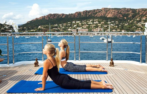 Charter guests do yoga on deck of luxury yachtMy Seanna