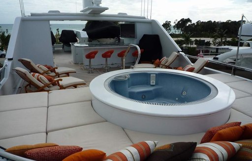 spa pool, sun pads, sun loungers and bar on the sundeck of luxury yacht CLAIRE