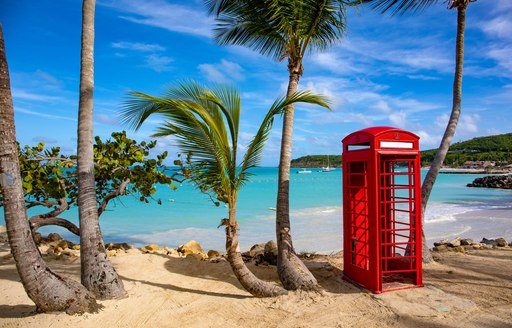 A sandy beach with a red telephone box in the British Virgin Islands