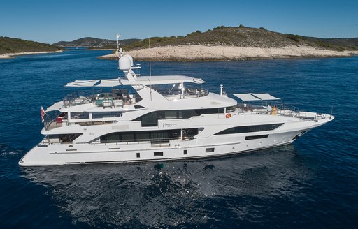 Charter yacht HAPPY ME at sea with island in the background