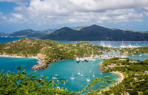 Shot of charter yachts gathered in Antigua bay with mountainous backdrop and blue seas