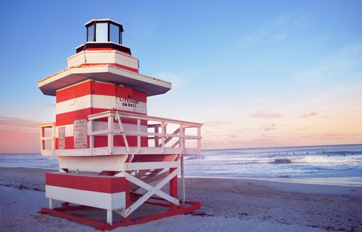 Red and white lifeguard post on a sandy beach