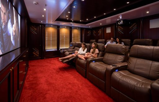 Interior cinema with charter guests watching film onboard charter yacht BOADICEA