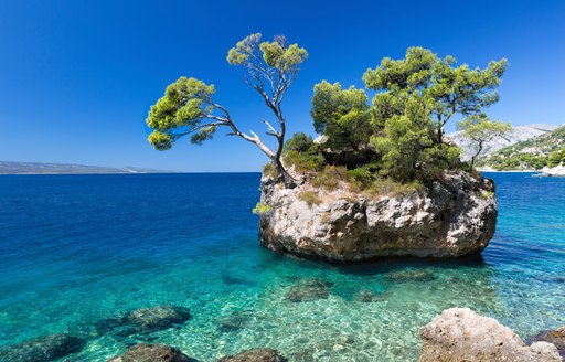 small islet in shallow blue water in yacht charter destination of croatia