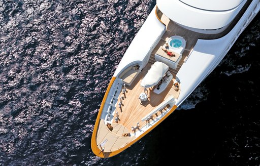 charter guest relaxes on sun pad on the foredeck of luxury yacht Utopia