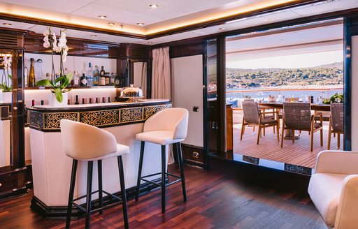 Wet bar and doorway to exterior deck onboard charter yacht IDYLLIC