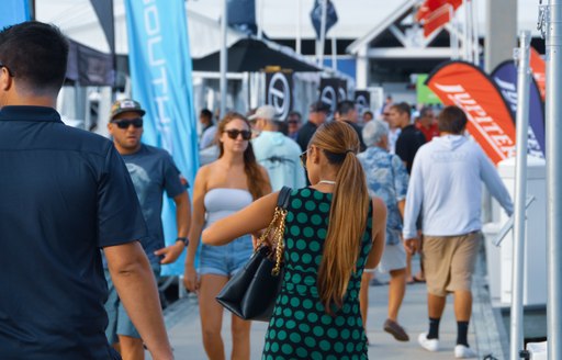 Woman on boardwalk at Fort Lauderdale International Boat Show reaching into her handbag