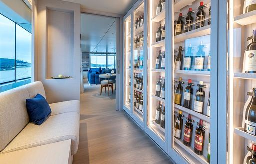 Display of wine and white sofas onboard charter yacht ARSANA