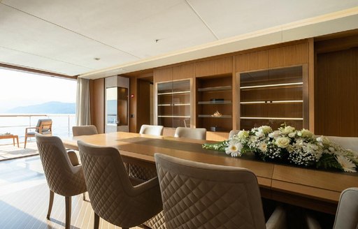 Interior dining set up onboard charter yacht ALFA with fold-down balcony visible in the background