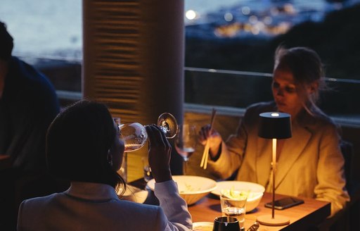 Two women dining at dusk 
