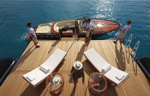 Swim platform with sun loungers and a tender adjacent onboard charter yacht AMARYLLIS