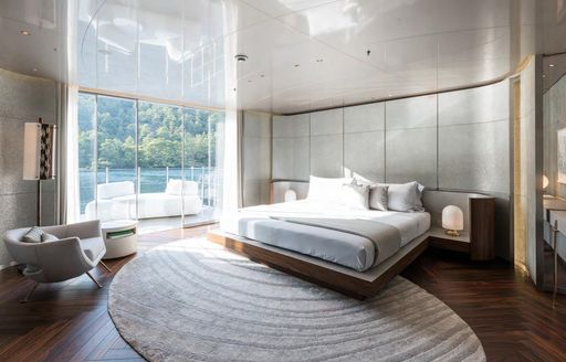 Lightly colored bedroom on superyacht SAVANNAH, with large window looking onto patio