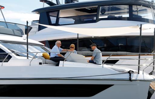 People in discussion on the bow of a motor yacht charter