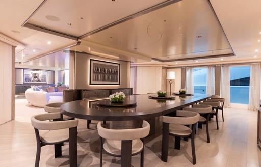 Charter yacht LUNA interior dining area with long table and white seats