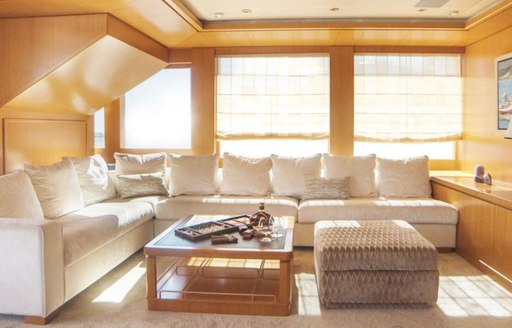 main salon of superyacht oasis, with high windows and light streaming in