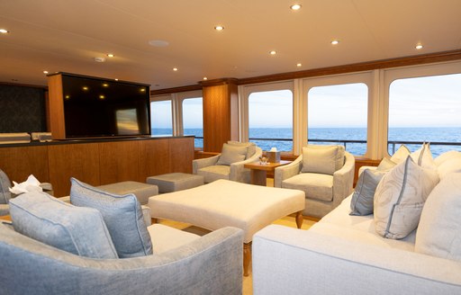 Comfortable skylounge with seats facing TV on superyacht ZEAL