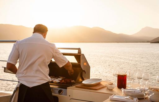 chef makes food on barbecue on superyacht