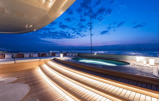 recessed spa pool on sundeck of luxury yacht SAVANNAH as the sun sets over the ocean