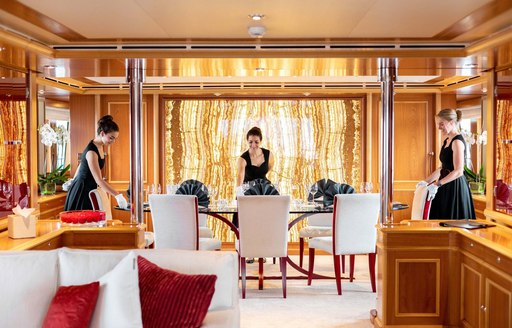 luxury yacht crew make table in dining salon