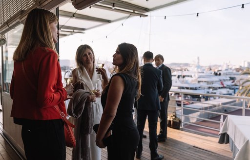 attendees at The Superyacht Show in OneOcean Port Vell, Barcelona, socialise 