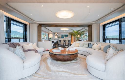 Interiors onboard charter yacht M with plush white sofas and armchairs