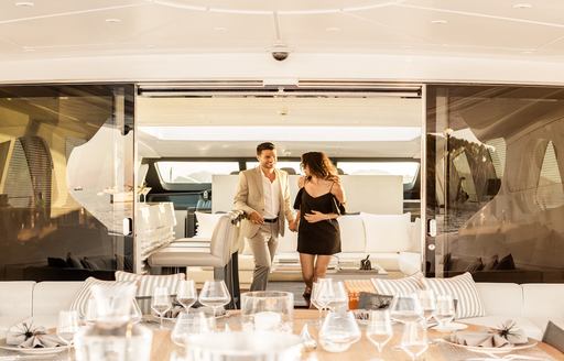 superyacht dining on the interior, couple walk towards table on charter