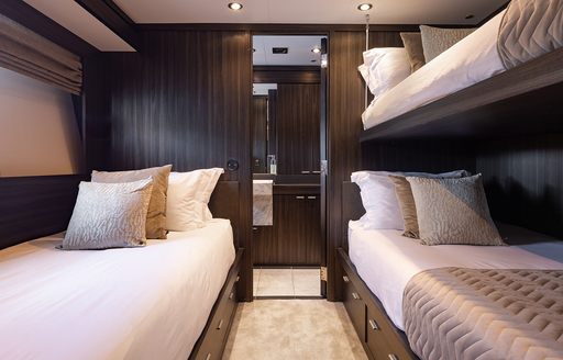 Guest cabin with bunk beds and a single berth onboard charter yacht BAGHEERA