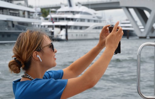 woman snaps picture of yachts at flibs