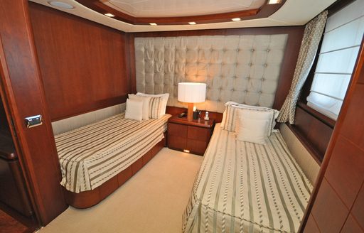 Twin cabin with two single berths and a lamp in between onboard boat charter VIVERE