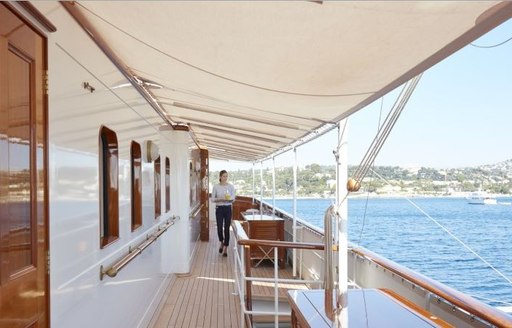 A charter guest navigates the walkaround deck layout of motor yacht MALAHNE