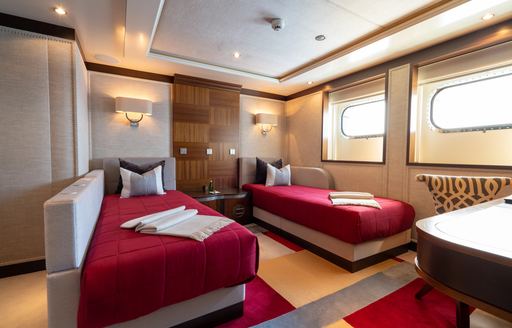Twin cabin with two single berths and adjacent windows onboard charter yacht KAISER