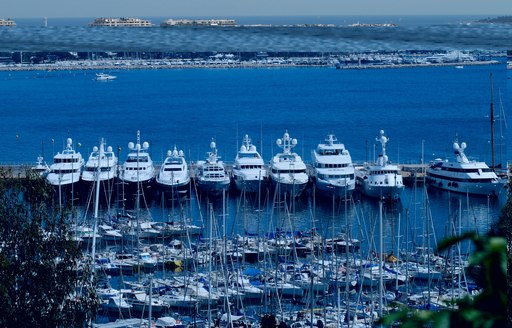 Superyachts lined up beyond smaller yachts in Cannes harbour